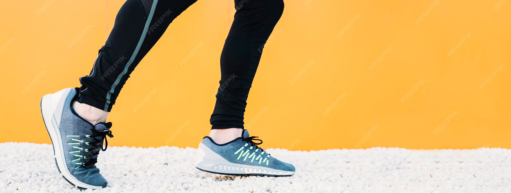 Person wearing blue running shoes on a yellow background